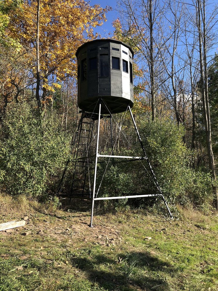 360 Pro hunting blind in black on a raised platform surrounded by trees