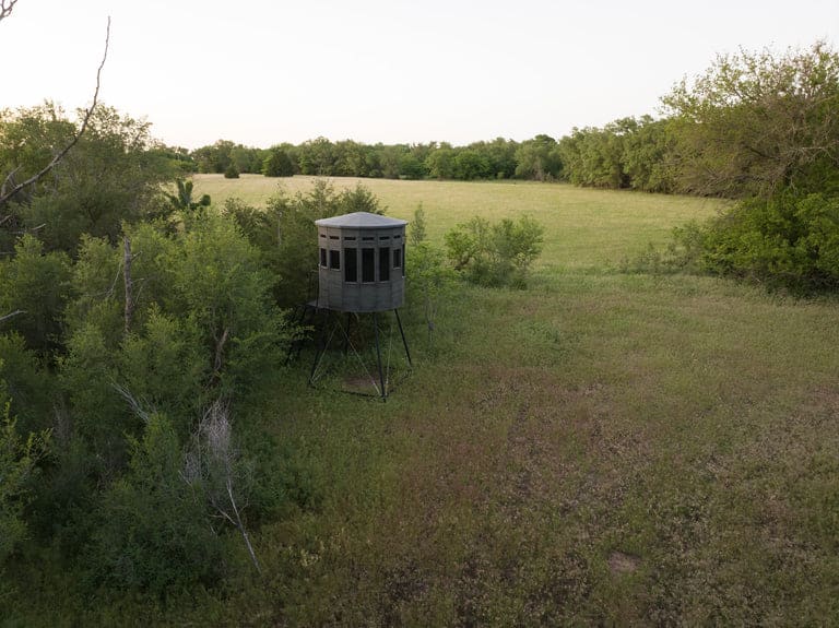 360 Pro hunting blind in a grassy field surrounded by trees.