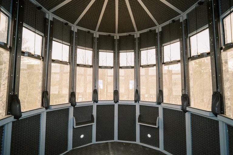 Interior view of a hunting blind with multiple windows and black walls